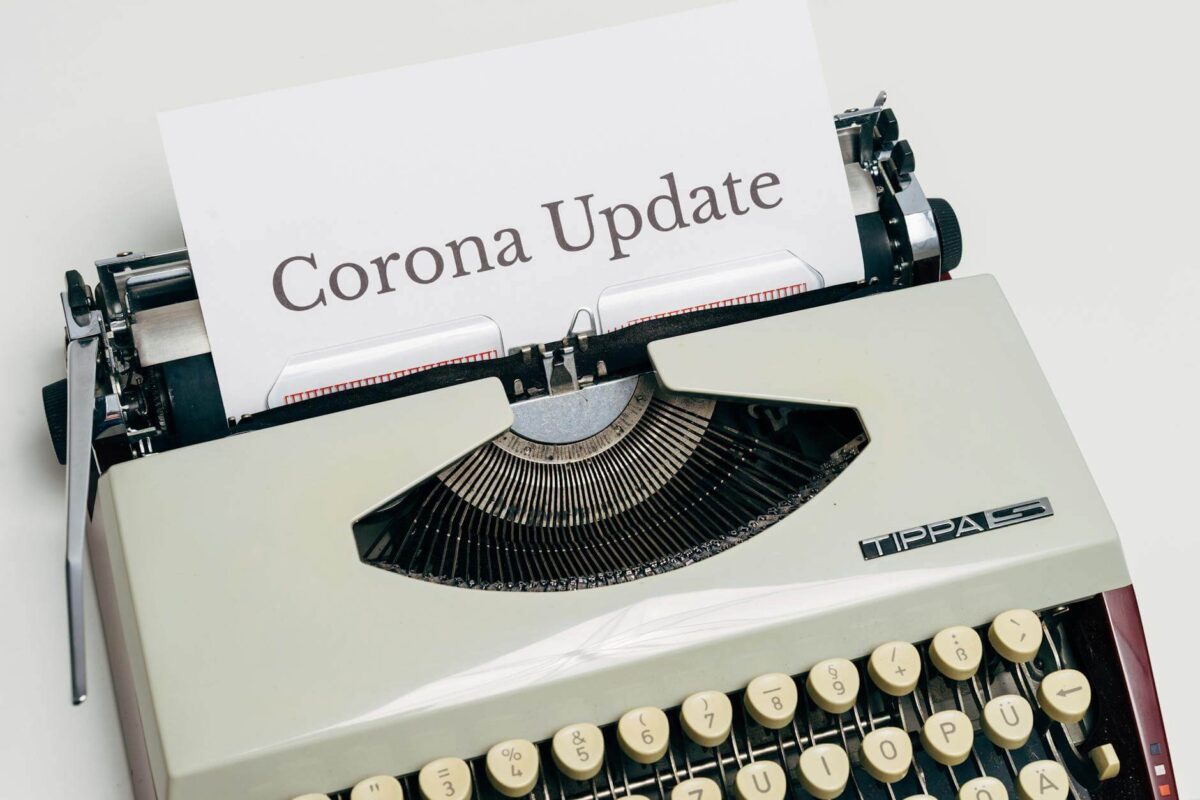 a vintage typewriter with corona update typed on white paper